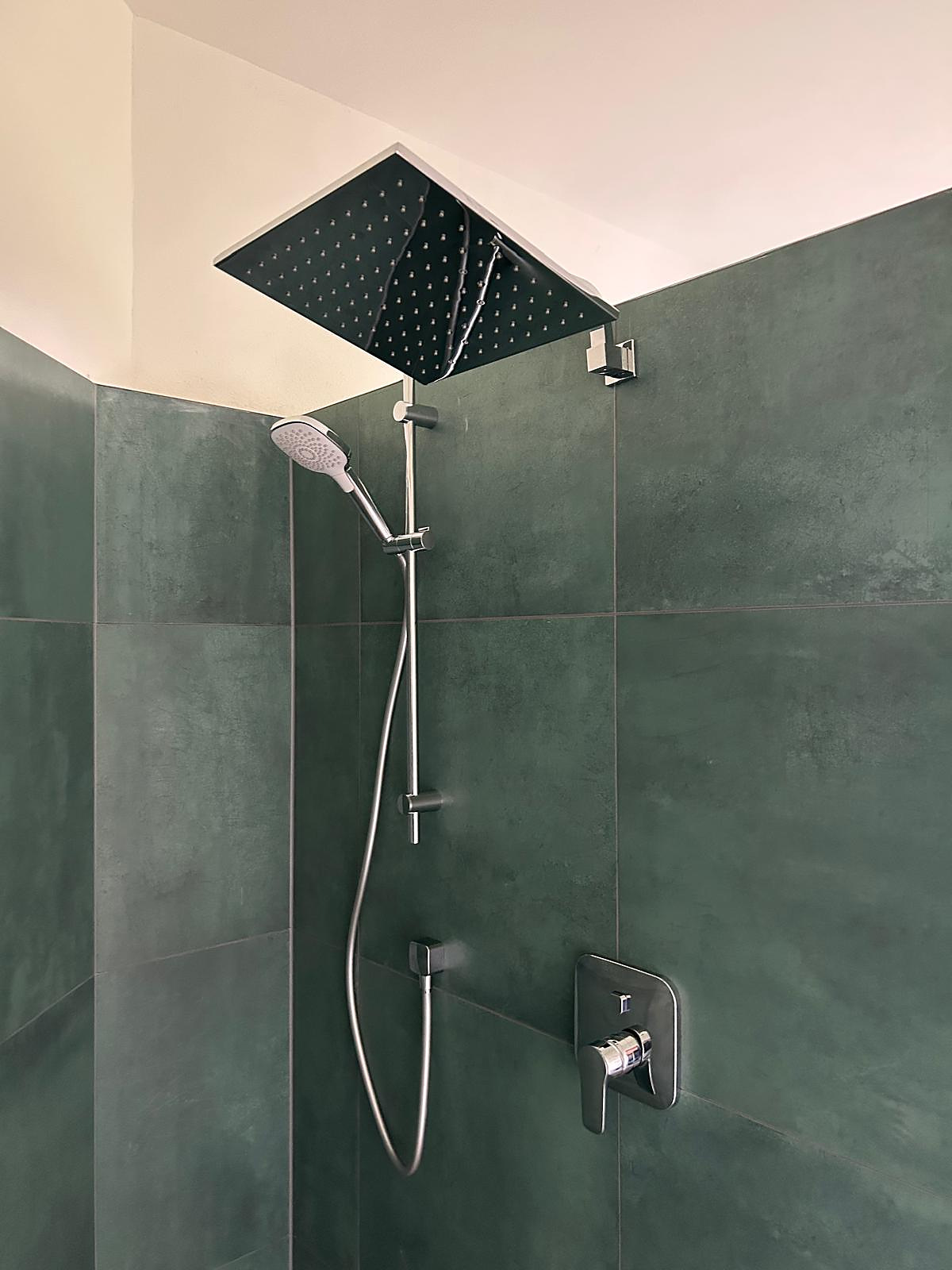 Dusche mit großer Regenbrause, Handbrause und grünen Großformatfliesen