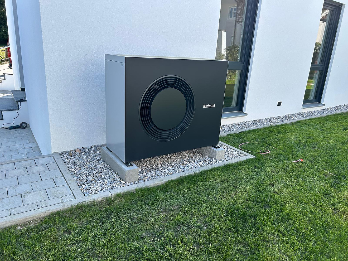 Buderus-Wärmepumpe auf Betonsockeln vor einer weißen Hauswand