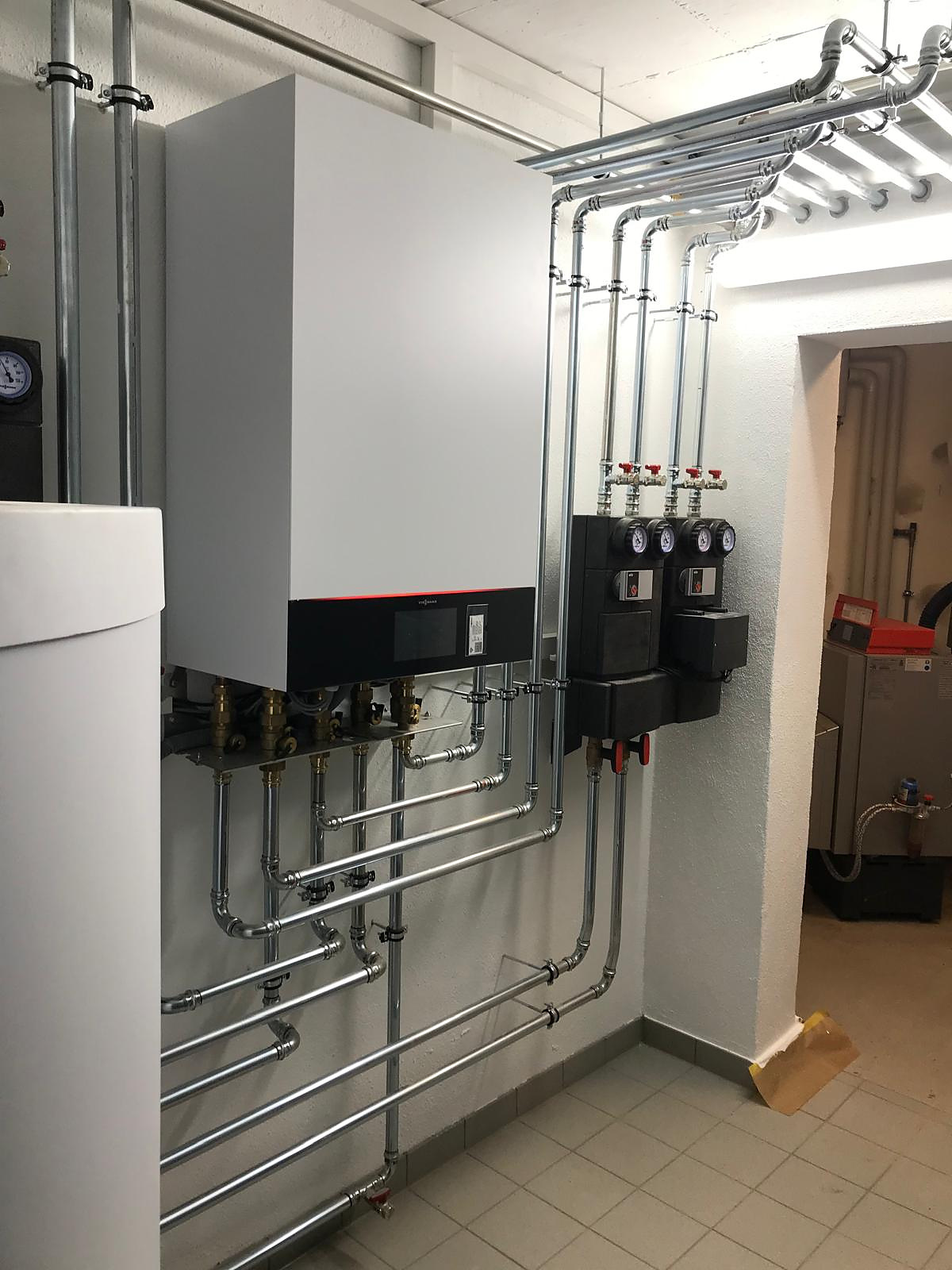 Wärmepumpen-Inneneinheit mit Pumpengruppen und Verrohrung im Technikraum